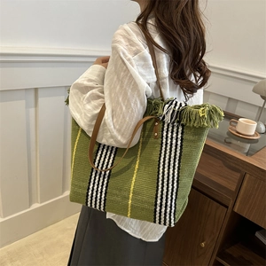 Bolso tote grande tejido con rayas verdes, detalles de flecos y asas de cuero marrón