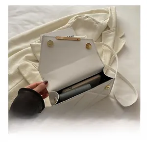 Internal view of the white quilted crossbody bag showing storage space for phone and wallet
