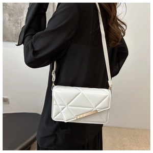 Detailed view of white quilted geometric texture on a stylish faux leather crossbody bag