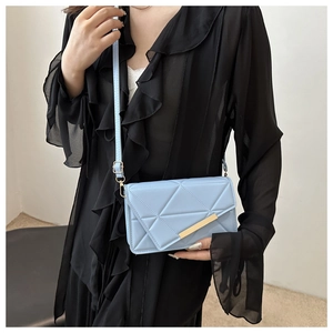 Quilted light blue square crossbody bag with geometric texture and gold metal detail