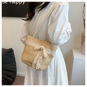 Detailed texture of straw woven tote bag featuring delicate white lace and a large bow