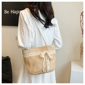 Detailed back view of a woven straw tote bag with delicate lace bow and twin straps