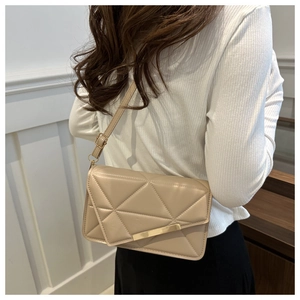 Detail view of beige quilted crossbody bag featuring a sleek gold metal buckle