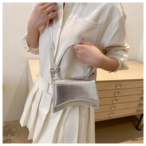 Silver crocodile embossed hourglass handbag with detachable shoulder strap worn by model