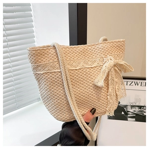 Detailed close-up of cream woven tote bag with lace trim and elegant bow decoration