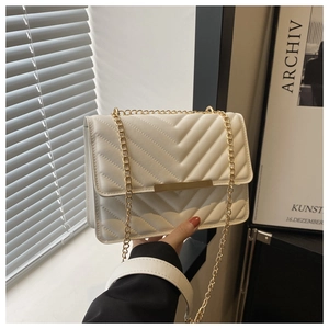 Detail of cream V-quilted faux leather bag with gold chain strap and metal clasp