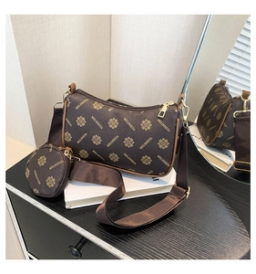 Detail of printed dark brown hobo bag with adjustable strap and small round charm
