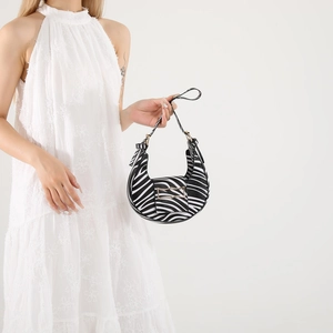 Stylish zebra print hobo bag with gold buckle accessory shown on a model