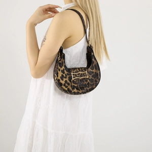 Stylish leopard print crescent hobo bag with gold metal buckle shown on a female model