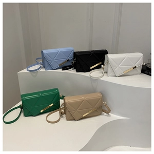 Close-up of geometric quilted crossbody bags with golden metal bar detail in multiple colors