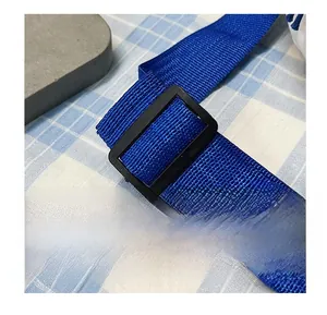 Detail of blue woven shoulder strap with adjustable black plastic buckle on chest bag
