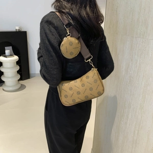 Brown monogram underarm saddle bag set with wide strap worn by a model in casual style