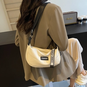 Chic beige lychee leather half-moon shoulder bag with adjustable black strap and fashion labels