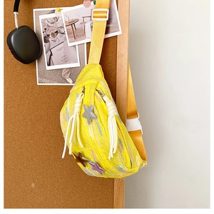 Detailed texture of yellow pleated nylon chest bag with colorful 3D stars and embroidery