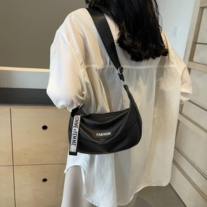 Chic black lychee leather crescent bag with fashion tag and stylish strap on white shirt