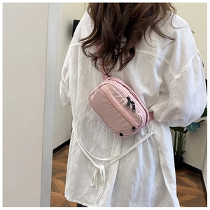 Close-up of pink nylon crossbody bag with dual zippers and matching fabric strap