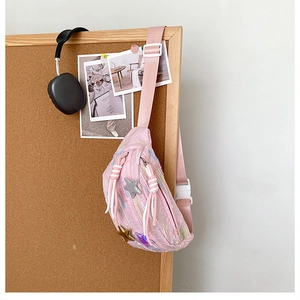 Detailed close-up of pink pleated nylon chest bag with star patches and striped cord zipper