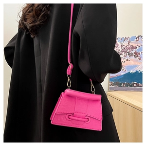 Detailed back view of a magenta mini crossbody bag with a roll-top flap and gold hardware