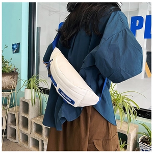 Detailed view of white canvas crossbody bag with blue zipper and WOAINI silicone patch