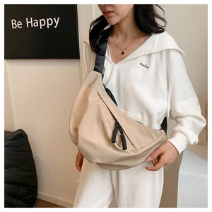 Borsa a tracolla beige in nylon a forma di mezzaluna con cinturino nero su modella