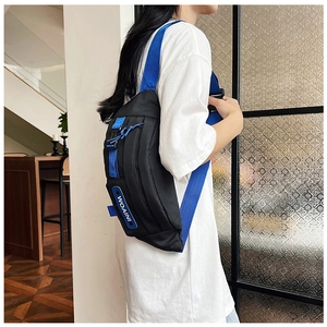 Detail of black nylon chest bag with bright blue adjustable strap and WOAINI patch