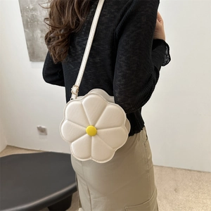 Borsa a tracolla a forma di fiore bianco con centro giallo e dettagli trapuntati su modella