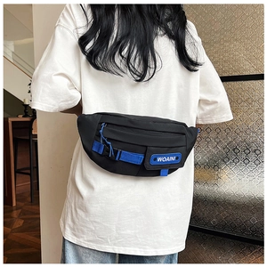 Detail of black nylon chest bag with blue ribbon accents and WOAINI logo tag