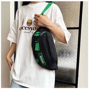 Detail view of black nylon chest bag featuring bright green straps and WOAINI logo patch
