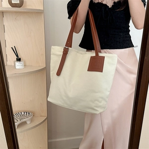 Minimalist large canvas tote bag with brown leather handles for daily commute