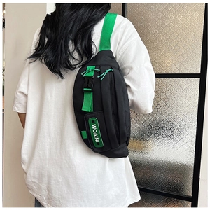 Detail of black tactical sling bag featuring vibrant green adjustable strap and zippers
