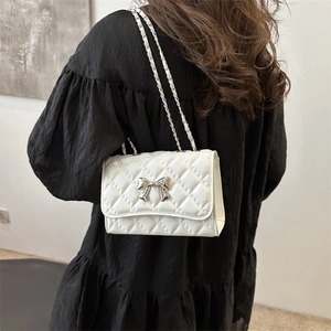 White quilted chain shoulder bag with silver bow accent and crossbody metal strap