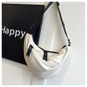 Dettaglio della borsa a mezzaluna in nylon bianco con cerniera nera e tracolla
