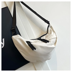 Dettaglio borsa a mezzaluna in nylon bianco con doppie cerniere e tiranti in corda