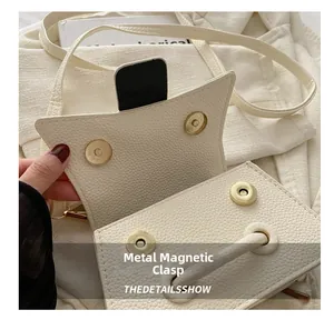 Detail view of the cream beige crossbody bag showing double magnetic closures and texture