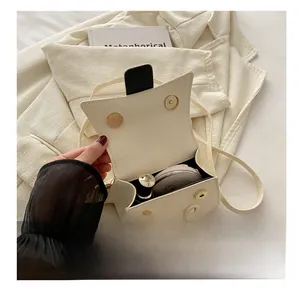 Interior capacity of cream crossbody bag showing space for cosmetics and lipstick
