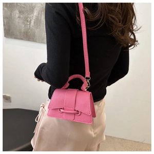 Detail view of pink lychee texture leather crossbody bag with gold metal hardware