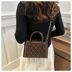 Dettaglio borsa a tracolla marrone vintage con cuciture trapuntate a cuore