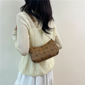 Vintage brown logo crescent hobo bag with gold chain strap shown on model shoulder
