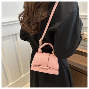 Detailed back view of model wearing a pink lychee texture mini crossbody bag with black dress