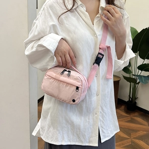 Pink minimalist crossbody bag for women featuring multi-zipper layers and woven strap
