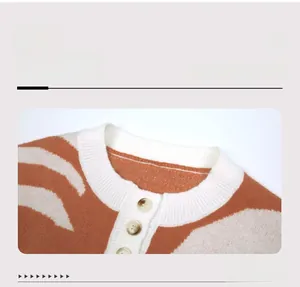 Dettaglio maglione in maglia jacquard a contrasto con bottoni ambrati e scollo a coste