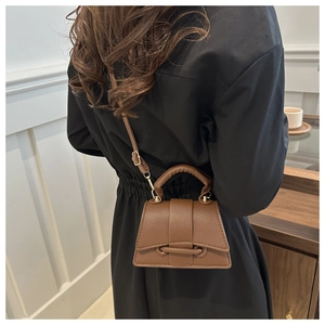Dark brown leather trapezoid bag shown on model for size and style perspective