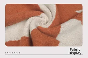 Dettaglio del tessuto a maglia color-block arancione e bianco crema, trama spessa
