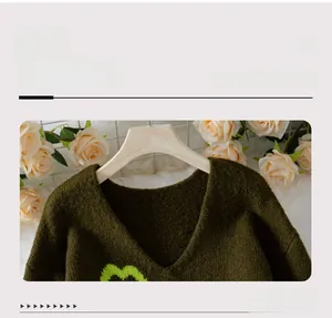 V-Ausschnitt-Detail des dunkelgrünen Strickpullovers mit hellgrünem Herzmuster-Design