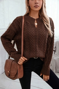 Detail of chunky cable knit texture on a brown vintage sweater with a V-notch neckline