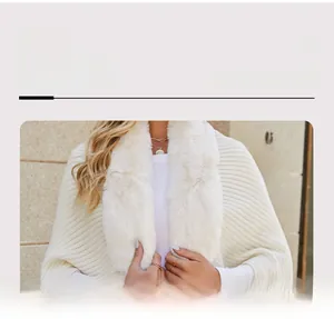 Detail view of cream knit shawl featuring a plush faux fur collar and ribbed texture