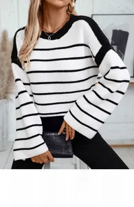 Detail of loose flared cuffs and black and white striped knit texture on woman sweater