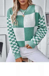 Close-up of the green and white checkerboard knit texture on a soft crewneck sweater