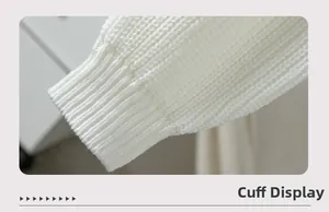 Detailed close-up of white chunky knit sweater cuff with vertical ribbed texture