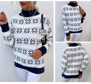 Close-up of white Christmas knit sweater with navy snowflake patterns and ribbed trims
